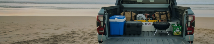 Back of a ute on a beach with camping gear and coolers seperated by a TubDivider